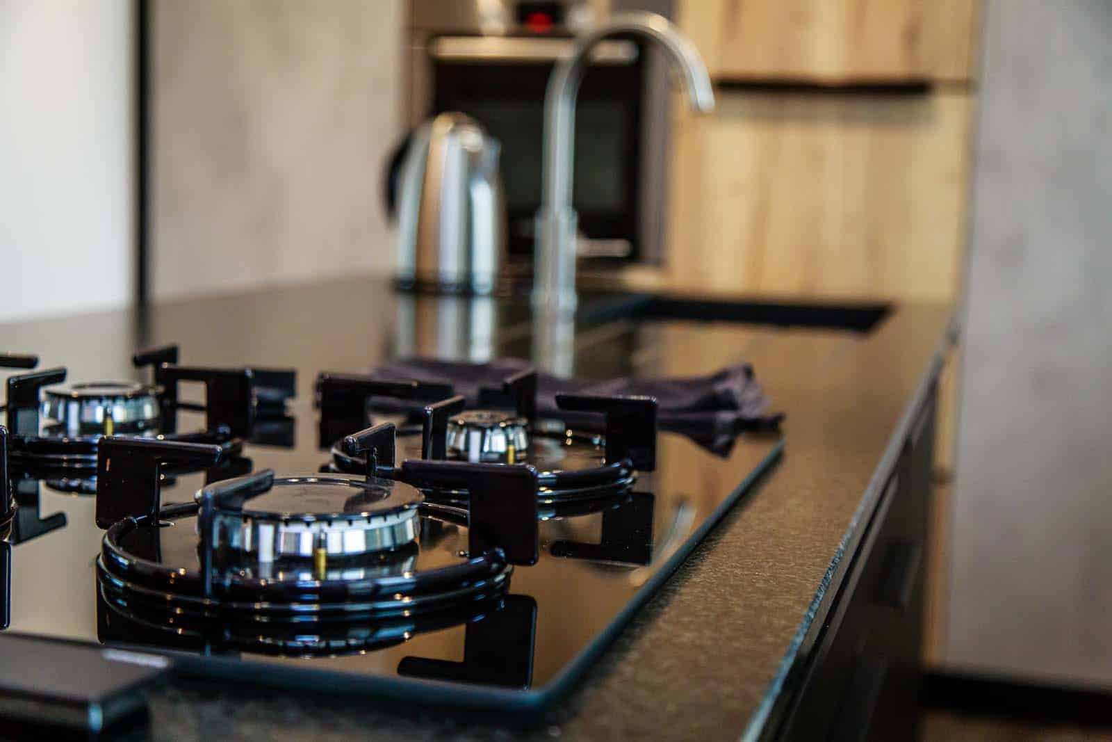 Cuisine sur mesure d’appartement à Guérande avec implantation en L et rangements toute hauteur.